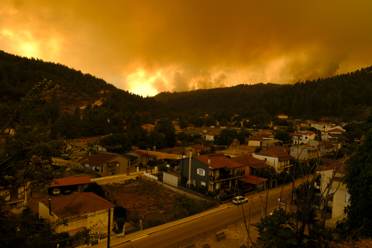A wildfire heading towards a village.