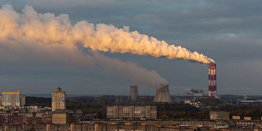 Smoke rising from smokestacks at a power plant.