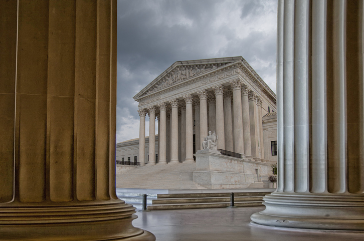 U.S. Supreme Court building framed by two columns.